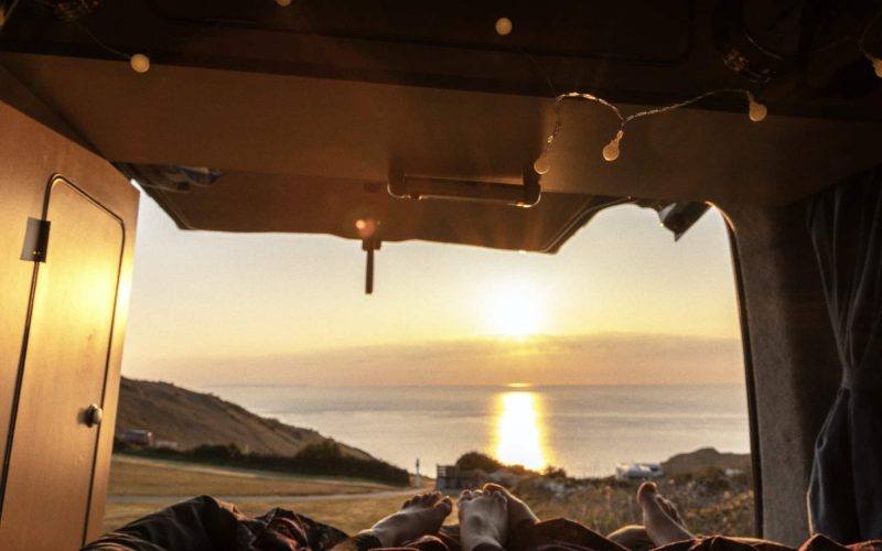 Camper van view looking out to sunset seas