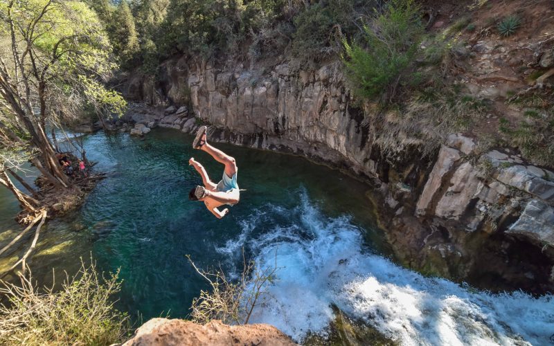 Man jumping off rocks in Arizona pool