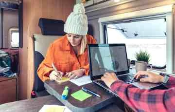 Woman and man telecommuting in a camper van