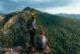 A man and a woman with backpacks on the mountain admire the panoramic view. Hiking